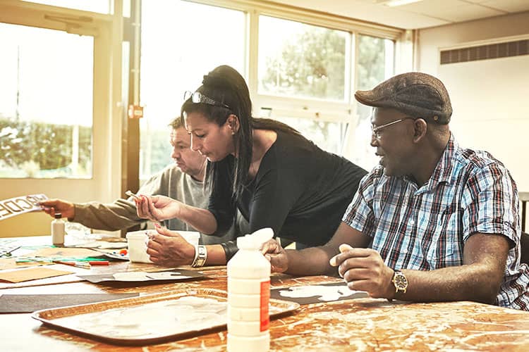 Disabled adults painting in care home